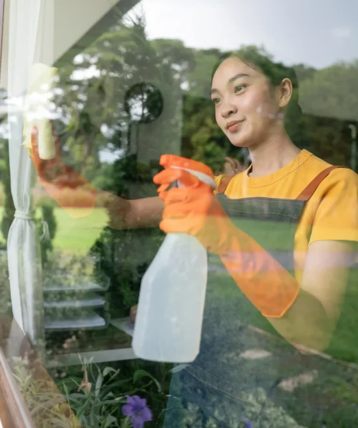 young-asian-housewife-cleaning-window-glass-with-r-2025-01-10-05-28-30-utc